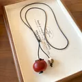 Close-up of bohemian ceramic necklace with persimmon-shaped pendant and patterned bead - Persimmon Shape