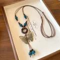 Detailed macro view of vintage butterfly pendant and blue ceramic beads on a cord necklace. - Butterfly Design