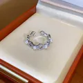 Primo piano di un anello placcato oro 18 carati con fiori di zircone e perle in una scatola. - Aperto Regolabile / Argento