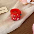 Close-up of a red dopamine-style wrinkled ring with colorful inlaid rhinestones. - Red