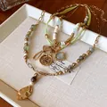 Vintage ethnic layered necklace featuring green beads and butterfly pendant details - Gold Green