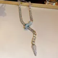 Detailed close-up of a silver-tone curb chain necklace with a rhinestone-paved snake head. - Silver