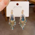Detail view of vintage court style tassel earrings with deep blue waterdrop crystals. - Water Drop Tassel Drop Earrings (HE26597) / Gold-Blue