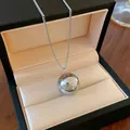 Macro view of a silver spherical pendant with the engraved quote "You deserve to be loved". - Silver