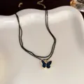 Elegant double-layered golden chain necklace featuring a sparkling blue butterfly pendant - Double Layer Snake Chain Butterfly Style / Black and Blue