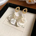 Detalle de elegantes pendientes dorados de estilo francés con flecos de nácar blanco en cascada - Estilo de Borla de Concha Geométrica con Poste de Plata / Dorado+Blanco