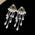 Detalle de pendientes de borla dorados con circonita y elegantes perlas de gota. - Estilo Gota de Agua con Borla / Oro-Blanco