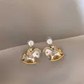 Detailed view of rocking horse pearl earrings with sparkling diamond-encrusted wings. - 4# Gold Color With Silver Earring Post
