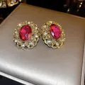 Close-up of vintage French style earrings with red main stone and gold floral border - Oval Shape / Rose Red