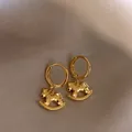 Exquisite close-up detail of golden rocking horse hoop earrings on smooth silk background - Gold Ear Clip Rocking Horse (27#)