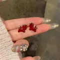 Detailed close-up view of red cartoon winged horse stud earrings with golden wings - Red Gold