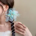 Detail of a blue fabric flower hair tie with a spiral telephone wire design on a braid. - Hair Tie / Green (Crystal Flower)
