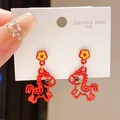 Dettaglio degli orecchini a cavallo rosso con accento floreale su carta bianca - Perno in Argento-Rosso-Stile 45