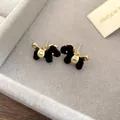 Primer plano de pendientes de caballo retro negro y dorado con textura de terciopelo - Pony Flocado Estrella Dorada (55#)