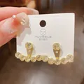 Detailed view of gold-plated earrings with sparkling cubic zirconia on a display card - T-Shaped Rhinestone Mesh Style / Gold