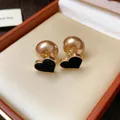 Close-up of elegant black flocked heart earrings with large champagne pearl backs. - Flocked Heart Style (HE29818) / Black