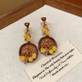 Detailed view of vintage Pipa-shaped earrings with yellow flowers and shiny crystals - Pipa Shape (WE6083) / Yellow