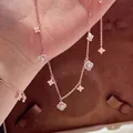 Close-up of rose gold flower jewelry set with zirconia and mother of pearl inlay - Gold