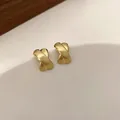 Eleganti orecchini a clip minimalisti in oro opaco a forma di croce con finitura metallica - 90 Punti - Oro.