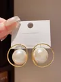 Close-up of elegant gold-plated hoop earrings with large lustrous white pearls. - Hoop (2#) / Gold