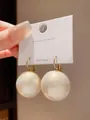 Macro detail of large cream pearl earrings with gold-plated S925 silver hooks on display card - Large Ball (5#) / Large / White