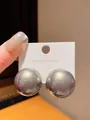 Close-up of large grey spherical stud earrings held on a display card with S925 silver needle - Round (7#) / Gray