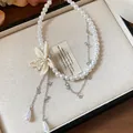 Close-up detail of beaded flower and teardrop pearl charms on a white beaded necklace - Khaki
