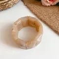 Close-up detail of a marbled acrylic rectangular block elastic bracelet in a beige tone - Off White