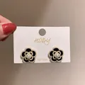 Vue détaillée d'élégantes boucles d'oreilles camélia noires avec perles et accents dorés. - Style Perle Camélia Noir et Blanc (Tige Argent 9#)
