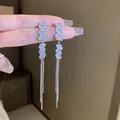 Detail view of elegant silver tassel earrings with sparkling rectangular crystal stones. - Geometric Tassel Style / 925 Silver Needle / Silver