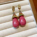 Close-up of vintage resin drop earrings with colorful rhinestones in a display box - Pink