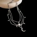 Detailed macro shot of a multi-layered silver necklace with star and moon charms - Three-layer Layered Style / Silver