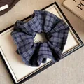 High-quality close-up detail of blue and grey plaid fabric scrunchie with ruffled texture - Blue