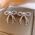 Elegant silver bow stud earrings with sparkling crystals and a central pearl accent - Pearl Rhinestone Style (30#)