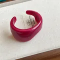 Close-up of deep pink translucent resin cuff bracelet with irregular marbled texture - Rose Red