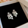Exquisite white enamel bow stud earrings with sparkling crystal flower accents on velvet - Triple Flower Enamel Style (19#)