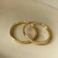 Close-up of minimalist gold geometric hoop earrings with polished metallic finish - Gold Plated Style (HE3123)
