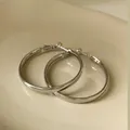 Macro view of minimalist silver geometric hoop earrings on a smooth ceramic surface - Silver Plated Style (HE3124)