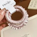 Detailed macro shot of pleated pink silk scrunchies on HenJu brand display card - Wrinkled / Pink