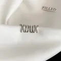 Close-up of elegant silver crisscross multi-layer zircon non-pierced ear cuff on white satin. - Crossover Multi-layer Style (HE13944) / Silver