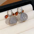 Close-up of retro glass petal tassel earrings with silver finish and amber accents. - Petal Tassel Hoop Earring (WE5957) / Light Coffee Gold with Amber