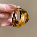 Gros plan détaillé de créoles rétro à imprimé léopard en résine avec fini brillant - Boucles d'Oreilles Rondes en Acétate / Marron