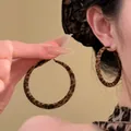 Dettaglio di orecchini a cerchio in resina con stampa leopardata su modella - 7# Grande Cerchio + Scrunchie / Leopardo Caffè