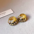 Nahaufnahme von vergoldeten Creolen mit schwarzem Emaille-Leopardenmuster im Vintage-Stil. - Dickwandiger Leopard Reifen (70#) / Gold