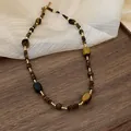 Detail view of a handcrafted irregular tiger eye stone necklace with golden beads - Tiger Eye Round Beads Style (2#)