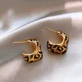 Gros plan sur des boucles d'oreilles créoles vintage en C avec motif léopard - Style Imprimé Léopard en Forme de C Or
