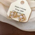 Detailansicht der exquisiten 18k vergoldeten Fleur-de-Lis Perlenohrclips mit Zirkonia - Clip-Ohrringe / Gold
