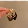 Dettaglio di orecchini a cerchio vintage stile Maillard con perline di occhio di tigre - Stile Circolare Con Perno in Argento (HE28809) / Marrone oro