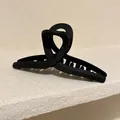 Matter schwarzer geometrischer Haarkrebs für elegante Dutt-Frisuren und Styling-Akzente. - Schwarze Kreuz-Haarklammer