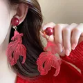 Detail showing red koi fish earrings with an intricate hollow metal design for New Year - Red Koi Ear Clip (1#) / Gold Red
